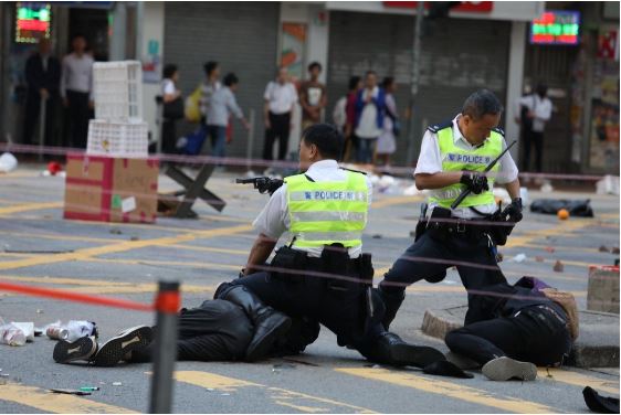 홍콩 경찰이 쓰러진 시위자를 제압하고 있다.(SCMP 제공)