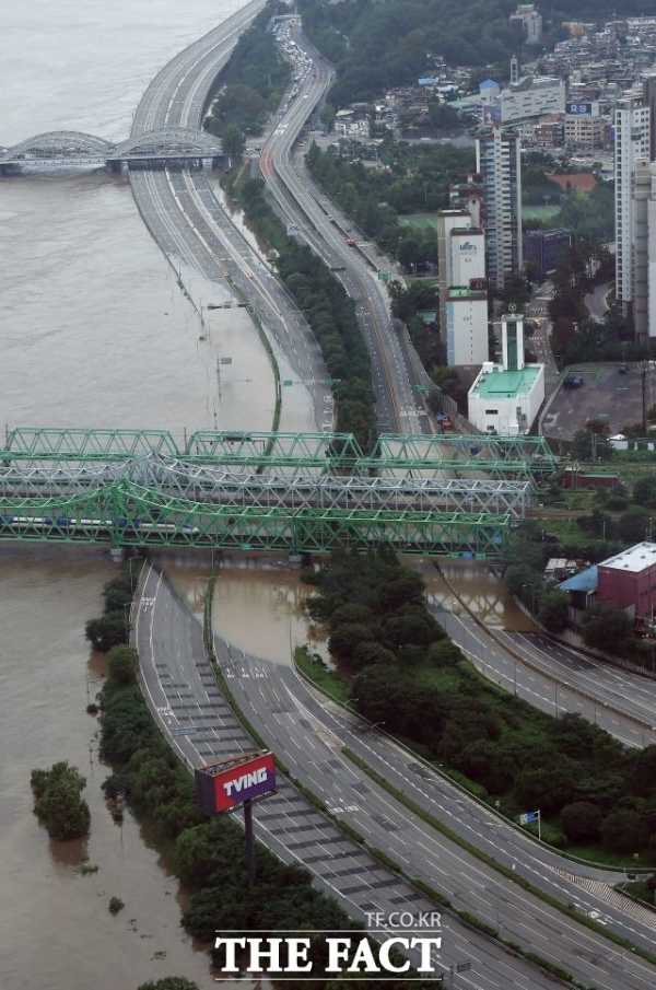 계속되는 폭우로 인해 지난 6일 오후 서울 영등포구 63빌딩 전망대에서 바라본 한강대교가 강물에 잠겨있다(사진: 더팩트 제공).