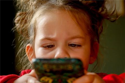 어린 아이가 눈을 찌푸리며 휴대폰을 쳐다보고 있다(사진: pixabay 무료 이미지).