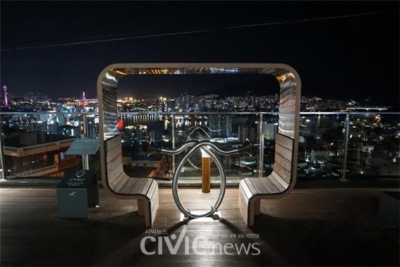 천마산 하늘 전망대의 소리 놀이 벤치 뒤로 야경이 반짝이고 있다(사진 : 취재기자 박가빈).