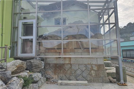 일본인 묘지를 집의 축대로 그대로 활용한 집이다. 바람 등으로부터 원형을 잘 유지하기 위해 투명한 벽으로 막아두었다(사진:취재기자 오현희).