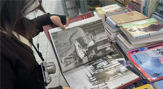 보수동 책방골목을 찾은 한 대학생이 책더미에서 오래된 책을 발견하고는 흥미롭게 읽어보고 있다(사진: 취재기자 김연우).
