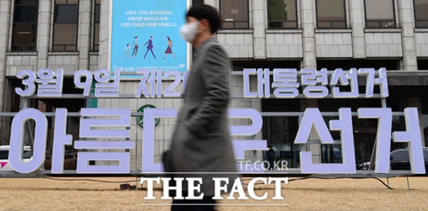제20대 대통령 선거 전, 서울 한국프레스센터 앞 광장의 대선 홍보 조형물 앞을 지나는 시민(사진; 더팩트 제공).