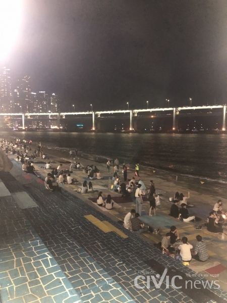 방범대원들이 바다와 맞닿아 있는 평지에 앉아 술을 마시는 시민들의 안전을 지키고 있다(사진: 취재기자 김연우).