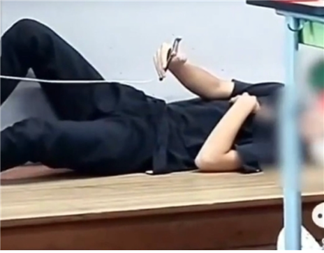 충남 홍성의 한 중학교에서 교사가 수업을 하는 동안 남학생이 교단에 드러누워 휴대론을 조작하고 있다(사진: 틱톡 영상 캡처).