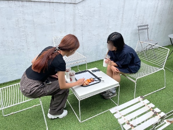 카페를 방문한 손님들이 허리를 굽혀 불편한 자세로 음식물을 섭취하고 있다(사진: 취재기자 탁세민).