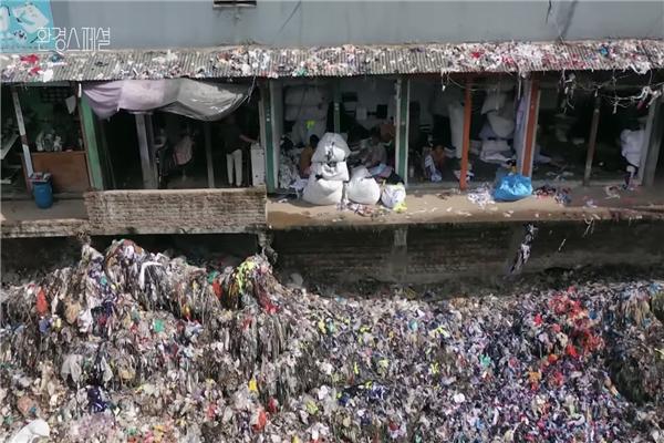방글라데시 주민들이 버려진 옷들 사이에서 생활하고 있다(사진: KBS 다큐멘터리 환경스페셜 ‘오늘 당신이 버린 옷, 어디로 갔을까?’ 캡처).